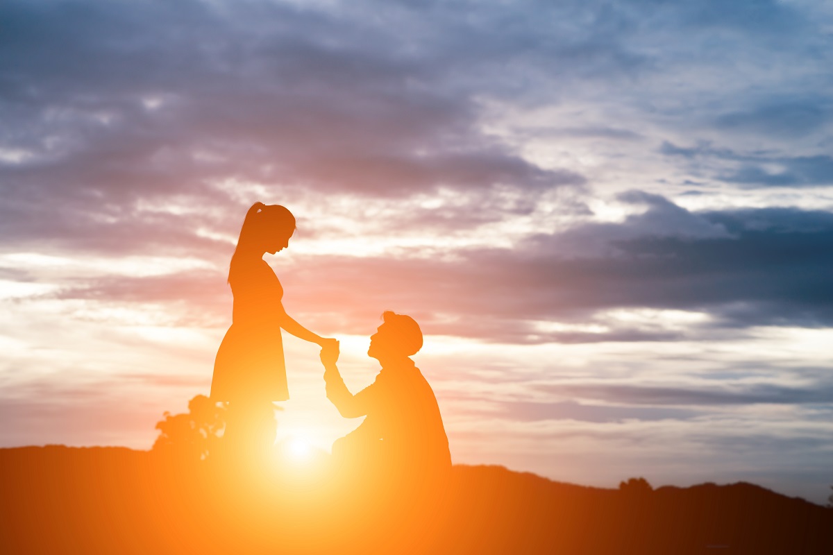 Silhouette Of Man Ask Woman To Marry On Mountain Background.