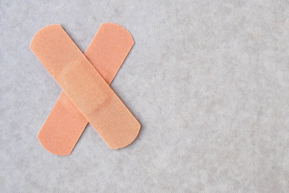 A Two Medical Plasters Of Cross Shape On Neutral Background. Patches From Injury.