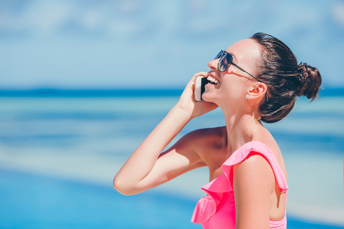 Young Beautiful Woman Talking By Phone On White Beach